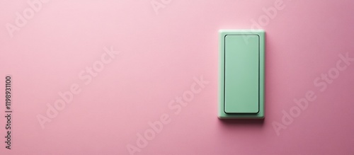 Green light switch on a pink wall with copy space for text or design element.