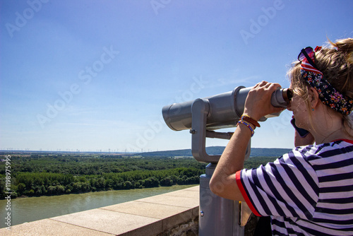 Photography blond girl in a striped T-shirt, portrait, looking through a telescope, from abo