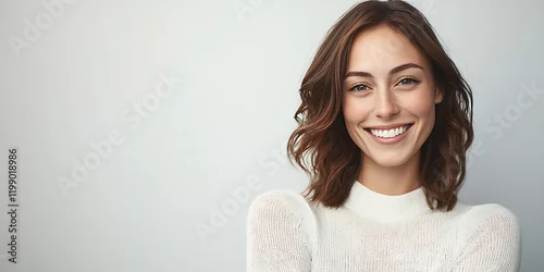Obraz Portrait of a young happy woman smiling and looking directly at the camera, with amazing details, high definition, and perfect composition. Capturing a joyful and confident expression with vibrant lig