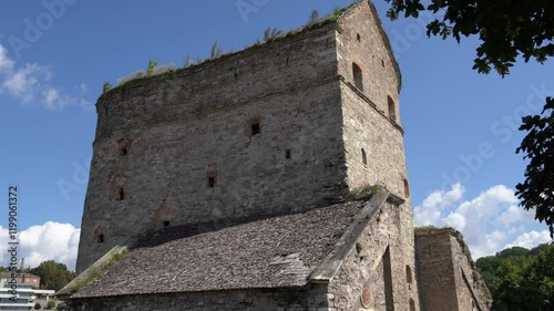 Medieval Bastion at Kamyanets-Podilskyi from side,Ukraine on a sunny day with white clouds.Tilt up from ground level to the ruined roof with bushes. photo