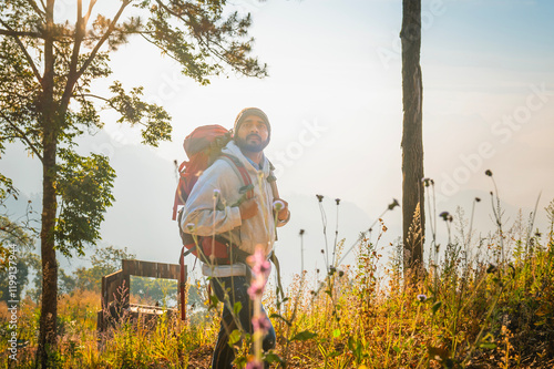 man is walking in the woods with a backpack on photo