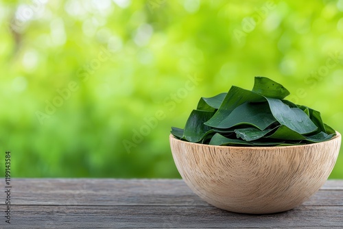 Seaweed is a nutritious superfood vagan food. Bowl of green leaves on wooden table with blurred background photo