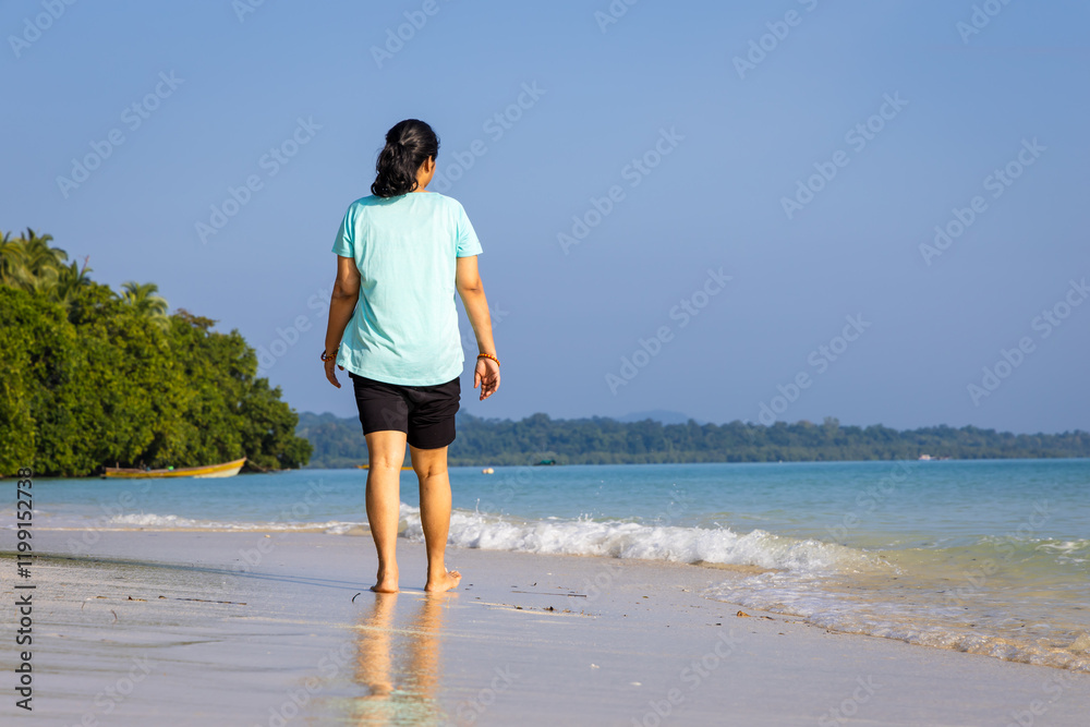 Isolated Girl relaxing at pristine Sandy Beach Shore with rolling waves in Morning Isolated Girl relaxing at pristine Sandy Beach Shore with rolling waves in Morning