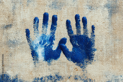 Two blue handprints are painted on rough textured fabric. Concept of art and creativity. For children's art projects