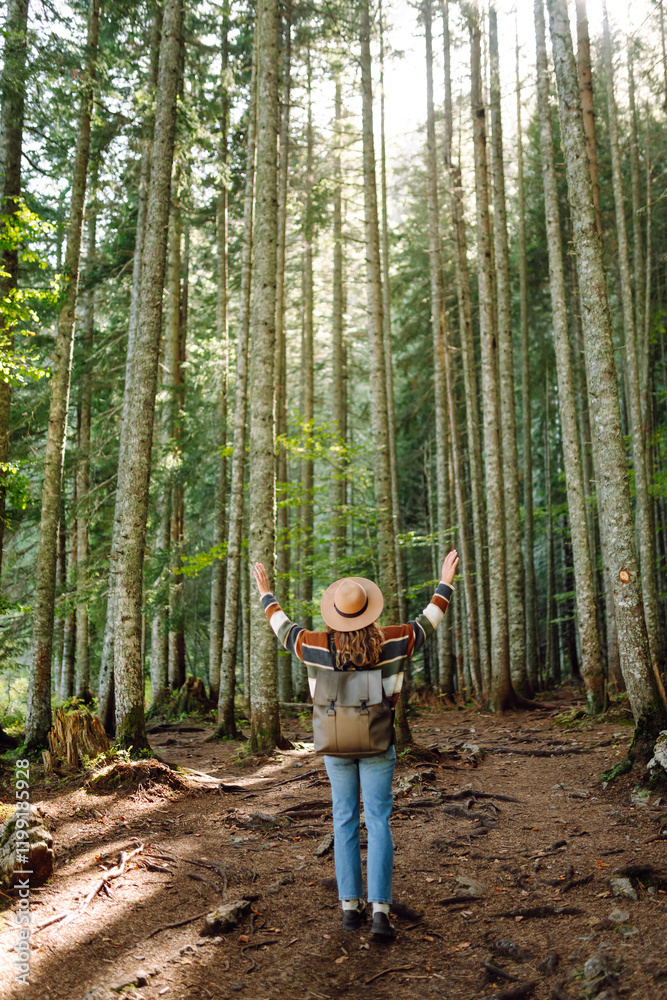 Woman with backpack hiking outdoors in the Forest. Trekking in the Pine Woods. Hiking, recreation and sports in nature. Woman with backpack hiking outdoors in the Forest. Trekking in the Pine Woods. Hiking, recreation and sports in nature.