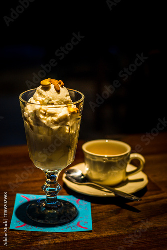 ice cream served with toasted peanuts on top and in  tall glass