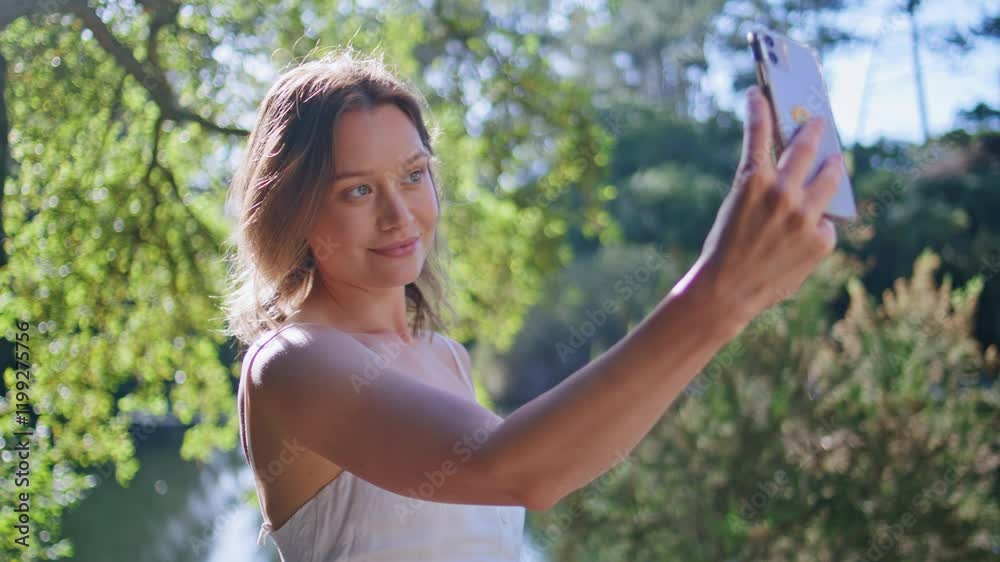 Cheerful girl posing phone camera greenery nature closeup. Woman making selfie Cheerful girl posing phone camera greenery nature closeup. Woman making selfie