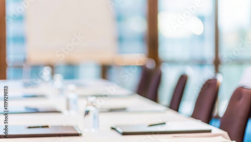 Meeting Room Setup Blur – Blurred view of a meeting room setup, featuring a table with notepads and pens, ready for a discussion.	
 photo