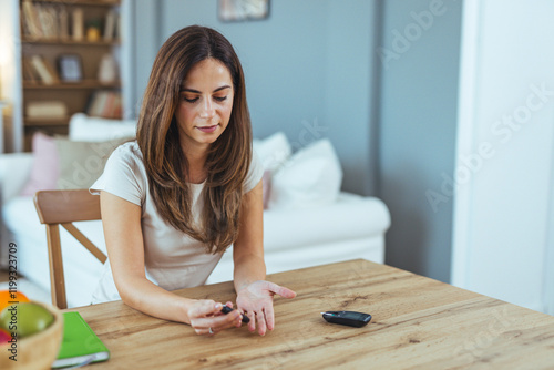 Woman Checking Blood Sugar Level With Glucometer At Home photo