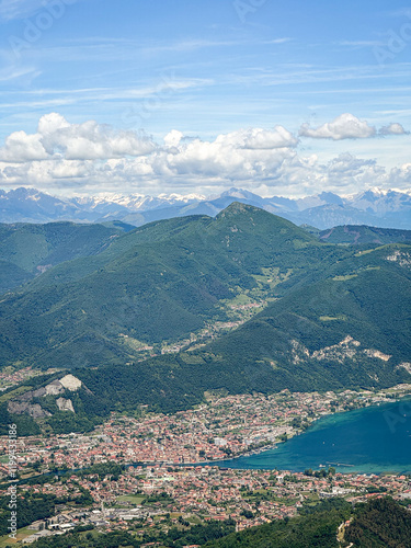 Areal view of town Sarnico and turquoise Lake Iseo in Italy and Swiss Alps with snow in mountaintops in the background. photo