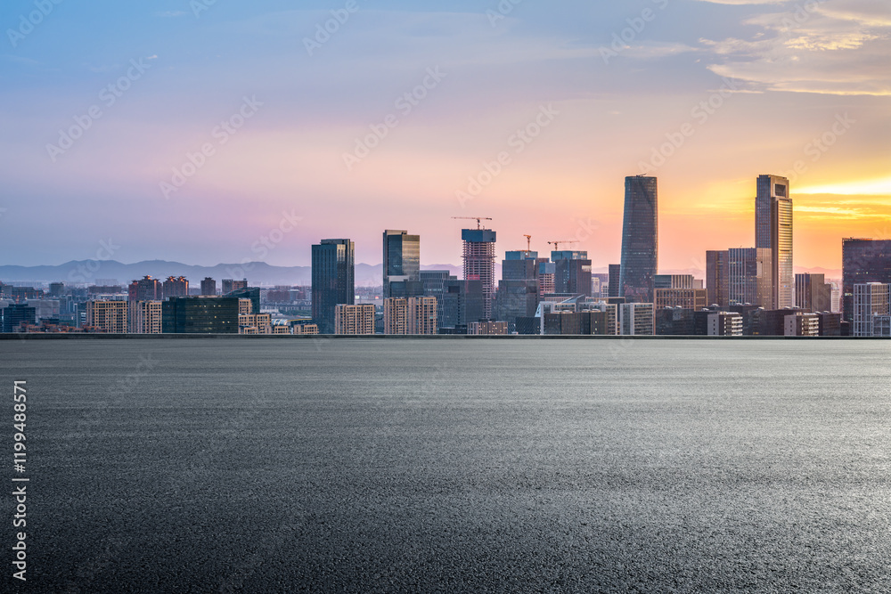 Empty asphalt road and modern city skyline at sunrise Empty asphalt road and modern city skyline at sunrise