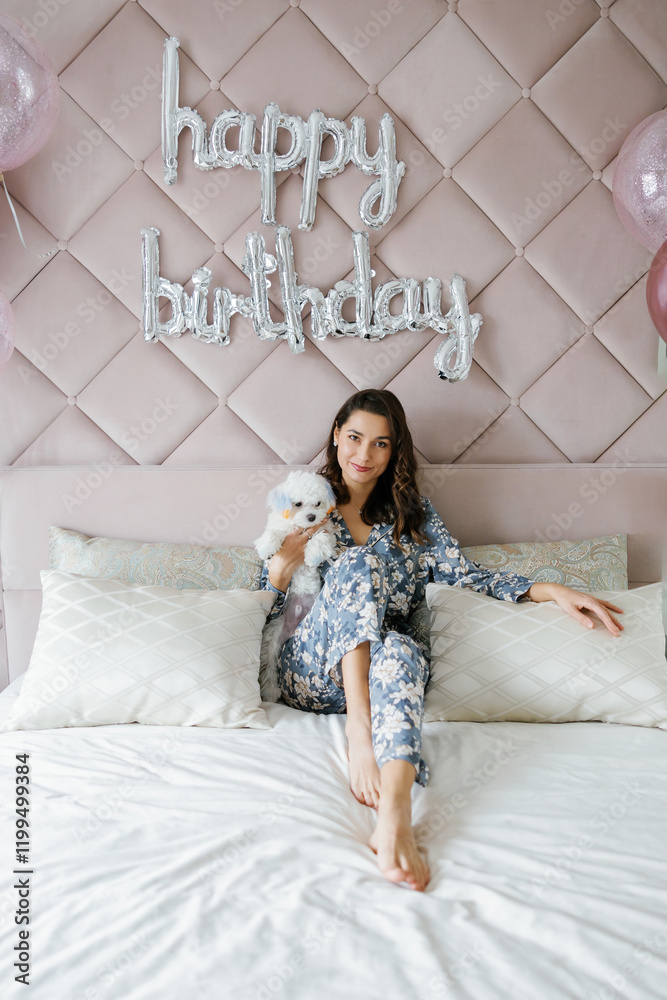 Fototapeta premium Woman celebrating birthday with her dog in bedroom