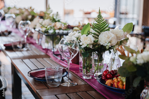 Luxurious dining table setup with flowers, appetizers, and wine glasses for an elegant celebration