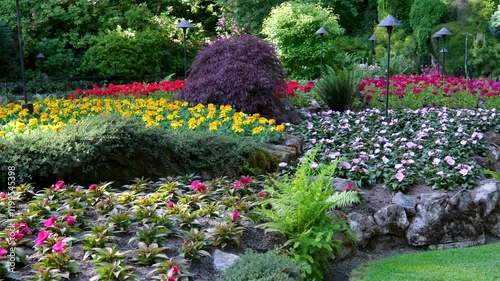 Victoria British Columbia, Canada Butchart Gardens National Historic Site of Canada, the Butchart Gardens, with tourists looking at the sights walking around paths in the Sunken Gardens. photo