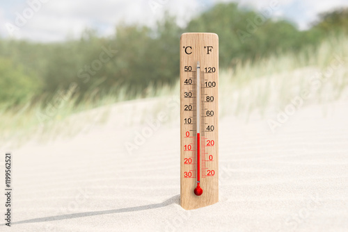 Wooden celsius and fahrenheit scale thermometer in the sand. Air temperature plus 3 degrees photo