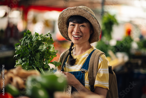 Portrait of a smiling asian woman shopping for fresh vegetables at the market photo