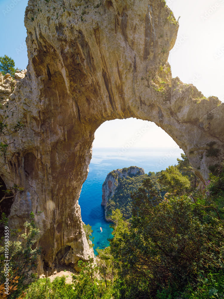 Fototapeta premium Natural arch on Capri, Italy, with stunning view of Mediterranean sea and surrounding greenery