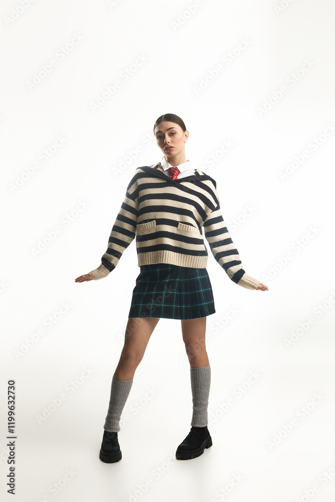 A young woman in a striped sweater and plaid skirt exudes joy and confidence. A young woman in a striped sweater and plaid skirt exudes joy and confidence.