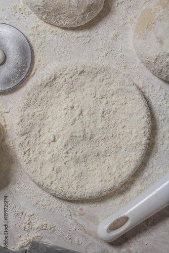 Massa de pão e pizza espelhadas com farinha, tudo numa mesa de pizzaollo