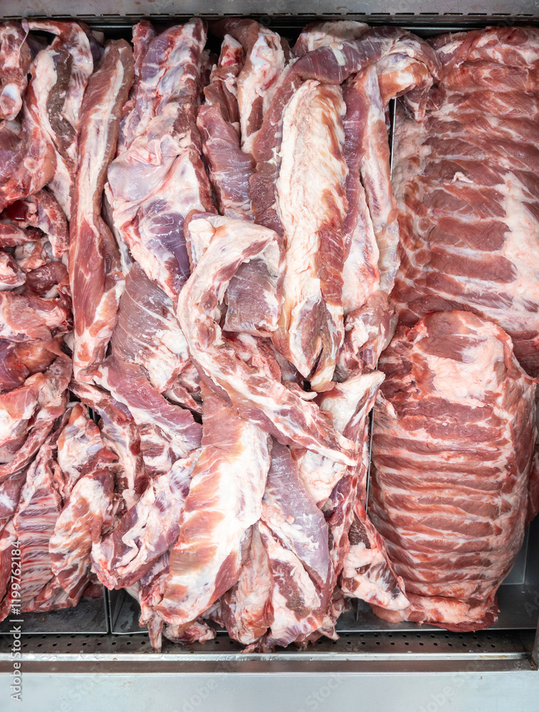 Fresh Pork Ribs and Tender Rib Cuts on Metal Tray in a Supermarket Display.