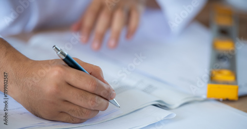 Photography A close up of a person's hand holding a pen and writing on a piece of paper