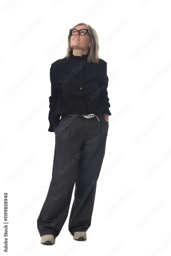 Front view of a woman dressed in dark clothing with hands in pockets looking up on white background Front view of a woman dressed in dark clothing with hands in pockets looking up on white background