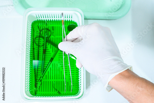 Dentist man putting items in sterilization tray for dental office items. Dental office, asepsis. Closed angle, close-up.
