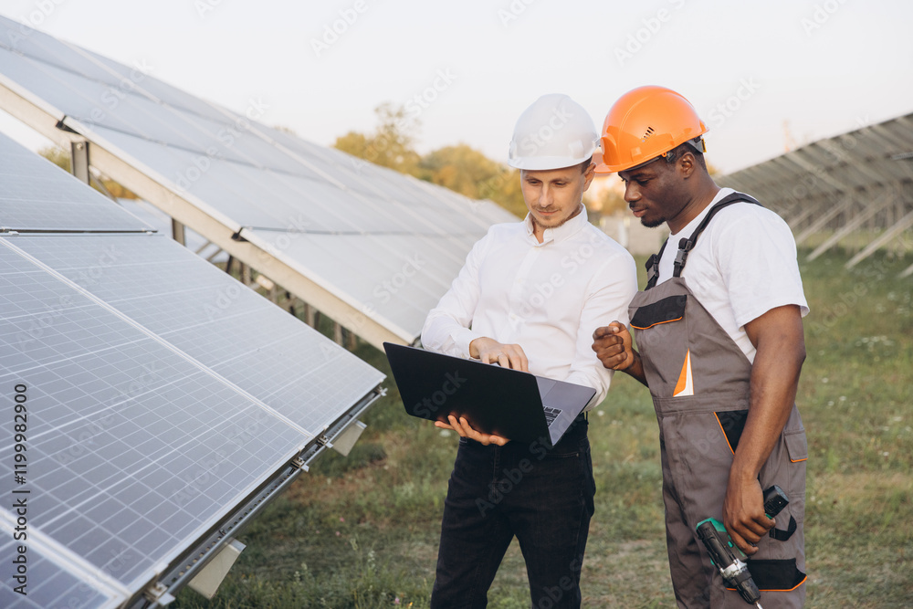Engineers Collaborating at Solar Panel Field with Laptop Engineers Collaborating at Solar Panel Field with Laptop