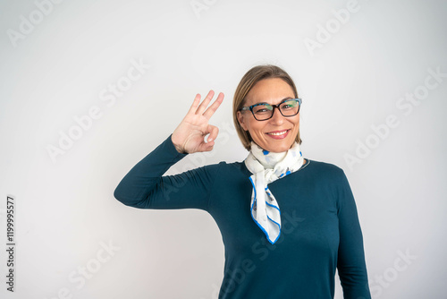 Portrait of a happy mature blonde businesswoman showing ok gesture. photo