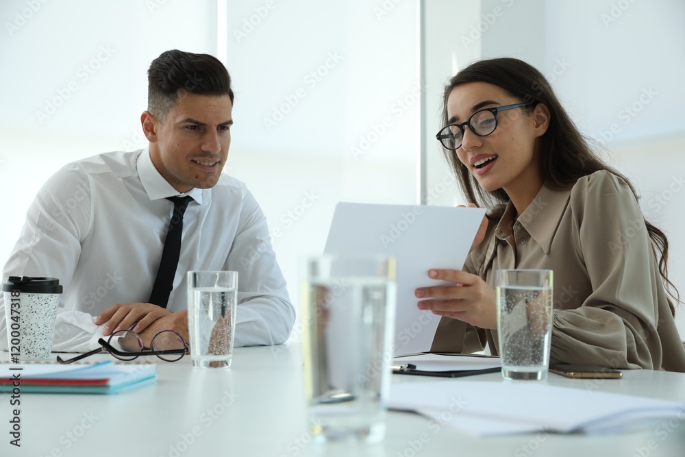 Office employees talking at table during meeting Office employees talking at table during meeting
