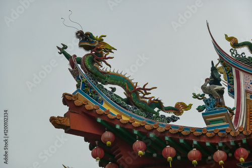 Vibrant dragon sculpture perched atop Chinese Thean Hou Temple roof. Statue intricate details like scales and claws. Festive atmosphere in traditional landmark. Kuala Lumpur, Malaysia, Southeast Asia photo