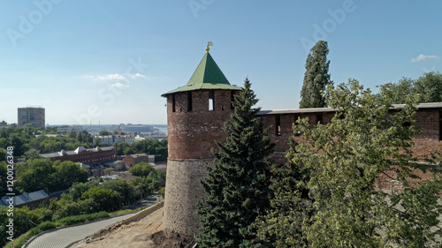 Brick tower with a green roof and a gold cross on top photo