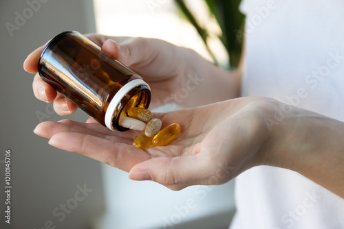 Woman pouring dietary supplements into her hand. Woman taking omega 3, omega 6, omega 9, fish oil capsules, vitamin D, vitamin C, magnesium. Take vitamin for treatment for skin, hair, nail.
