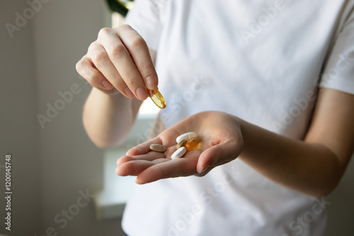 Quadro su tela Сlose-up of a woman's hands with various pills and supplements