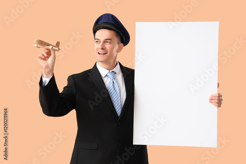 Handsome steward with blank poster and wooden airplane on beige background photo