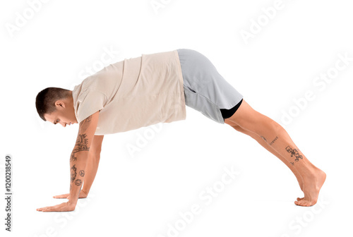Young man doing yoga on whi...