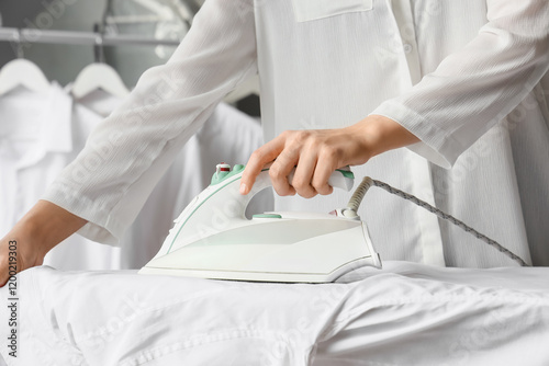 Woman's hand ironing a whit...