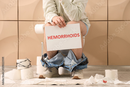 Young man holding paper wit...