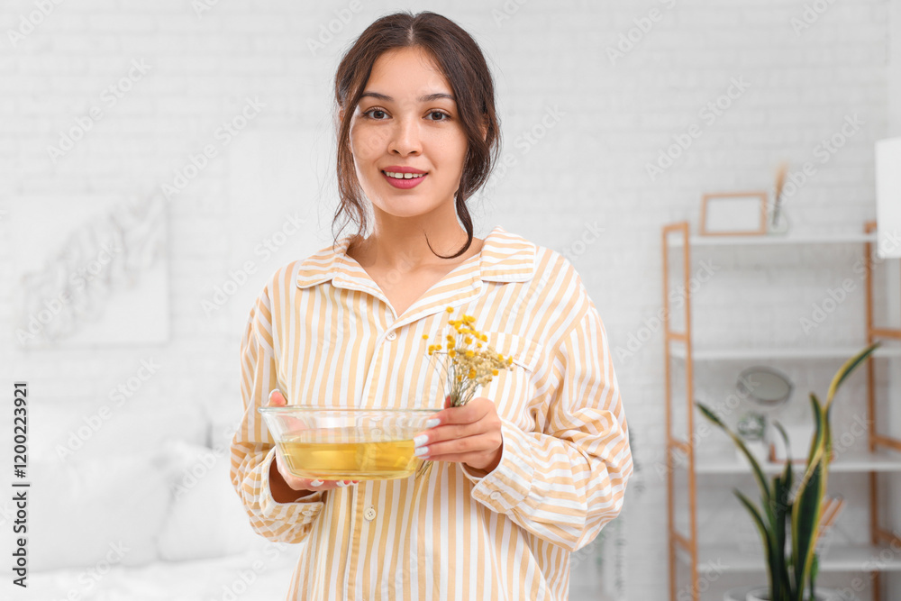 Young Asian woman with steam inhalation and herbs in bedroom Young Asian woman with steam inhalation and herbs in bedroom