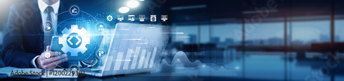 Software Developer using a tablet with a digital interface overlay showing code snippets, algorithms, technology graphs analysis, performance metrics, data flow, debugging tools, system architecture.