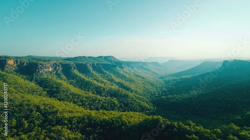 A serene view of Pachmarhi's lush green hills under a clear blue sky, showcasing the natural beauty of the landscape.