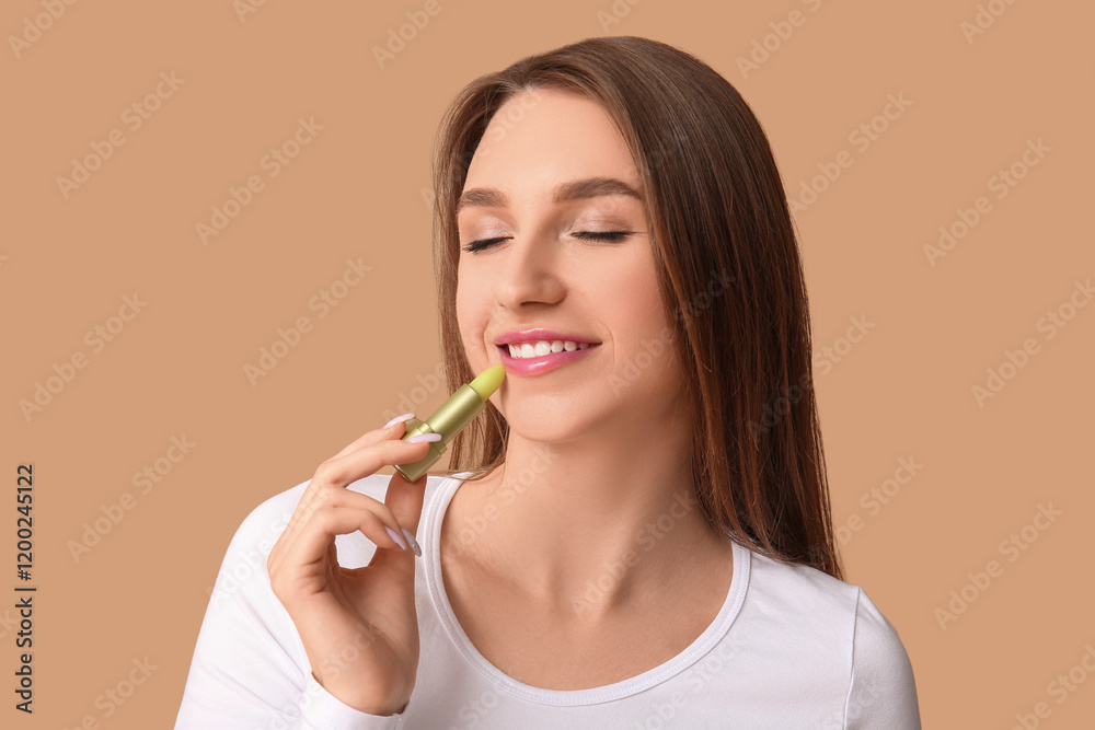 Beautiful young woman applying hygienic lip balm on beige background Beautiful young woman applying hygienic lip balm on beige background