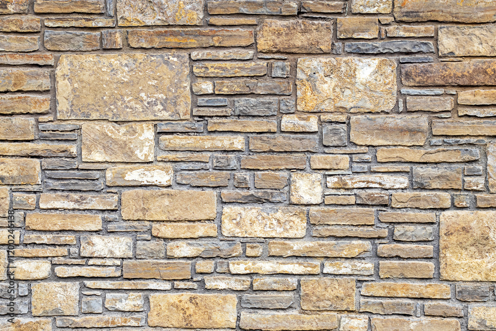 Fototapeta premium Stone wall with textured bricks arranged in a pattern for background use