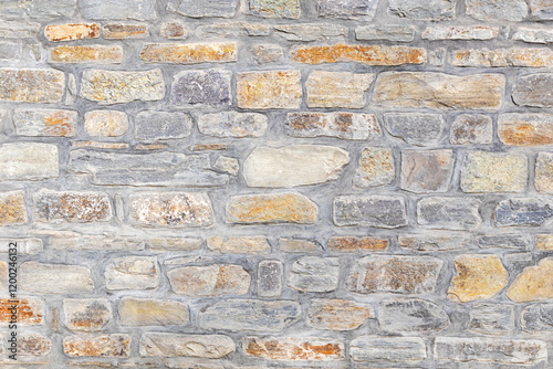 Natural stone wall with various shapes and colors creating a rustic texture