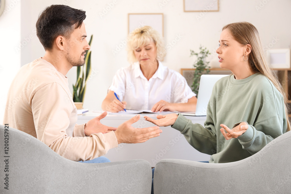 Obraz premium Upset young couple quarreling at psychologist's office