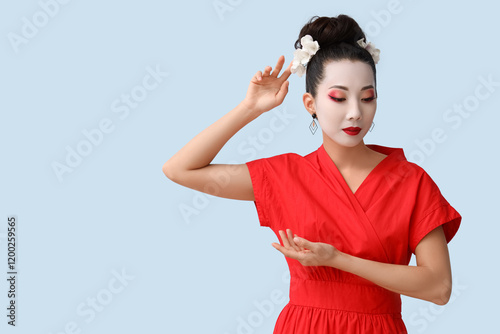 Beautiful young geisha on light background photo