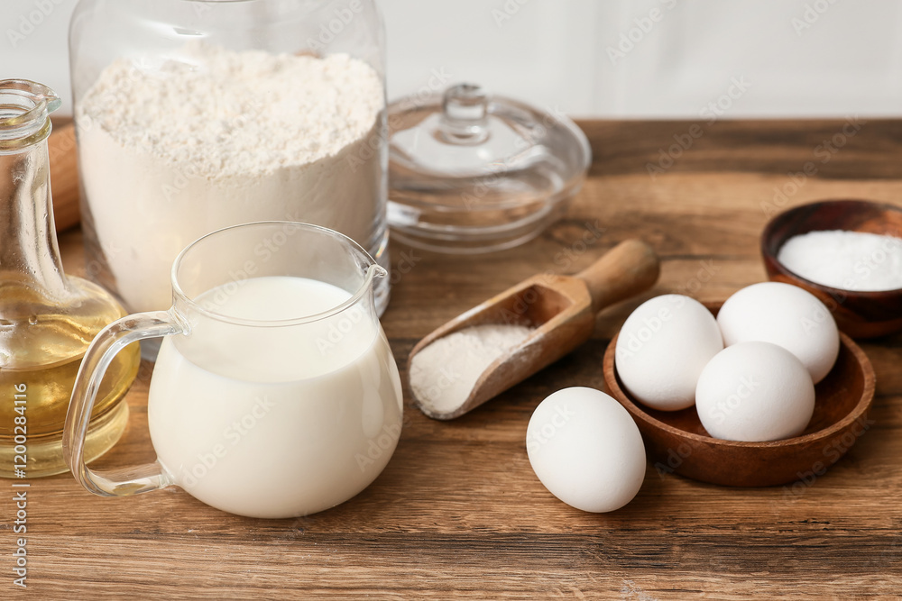 Flour in jar with eggs, scoop, jug of milk and oil for preparing dough on kitchen counter Flour in jar with eggs, scoop, jug of milk and oil for preparing dough on kitchen counter