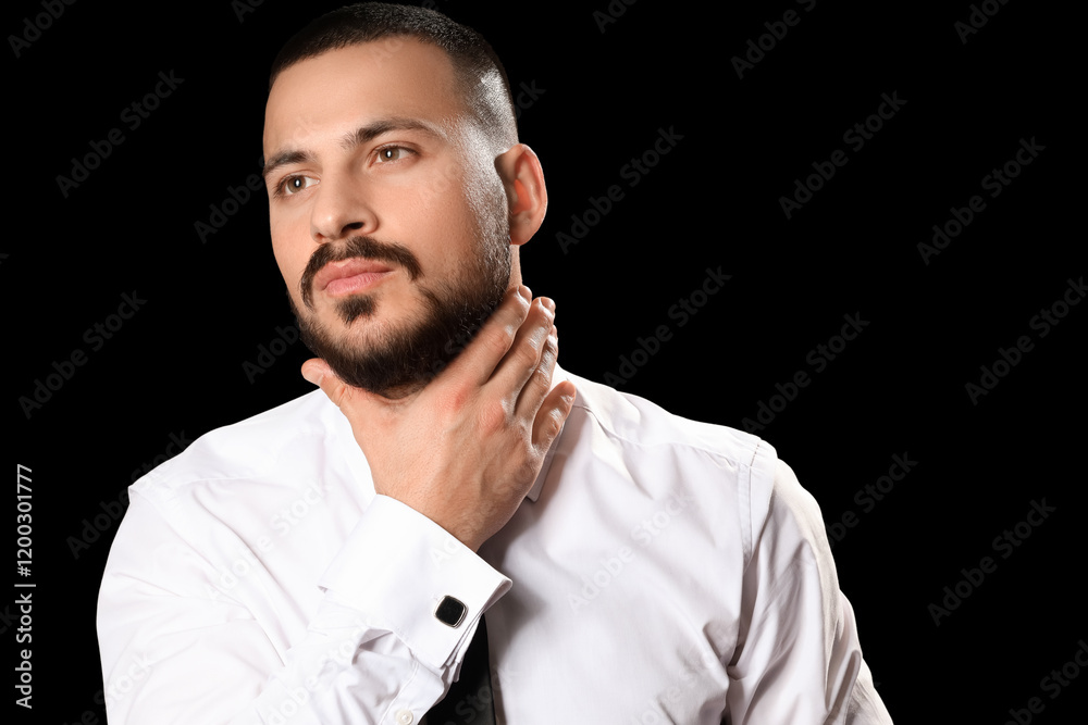Handsome young bearded man on black background Handsome young bearded man on black background