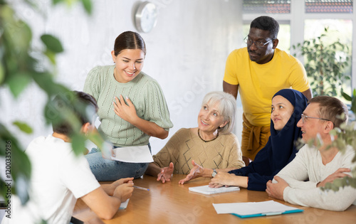 Group of multiethnic people doing discussing text of document at table in office