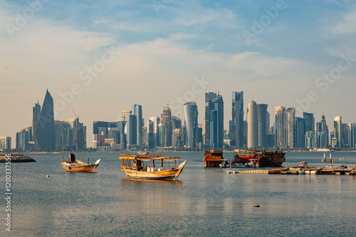 Wooden tour ships at seaside in Doha Qatar and cityscape with skyscrapers in the background